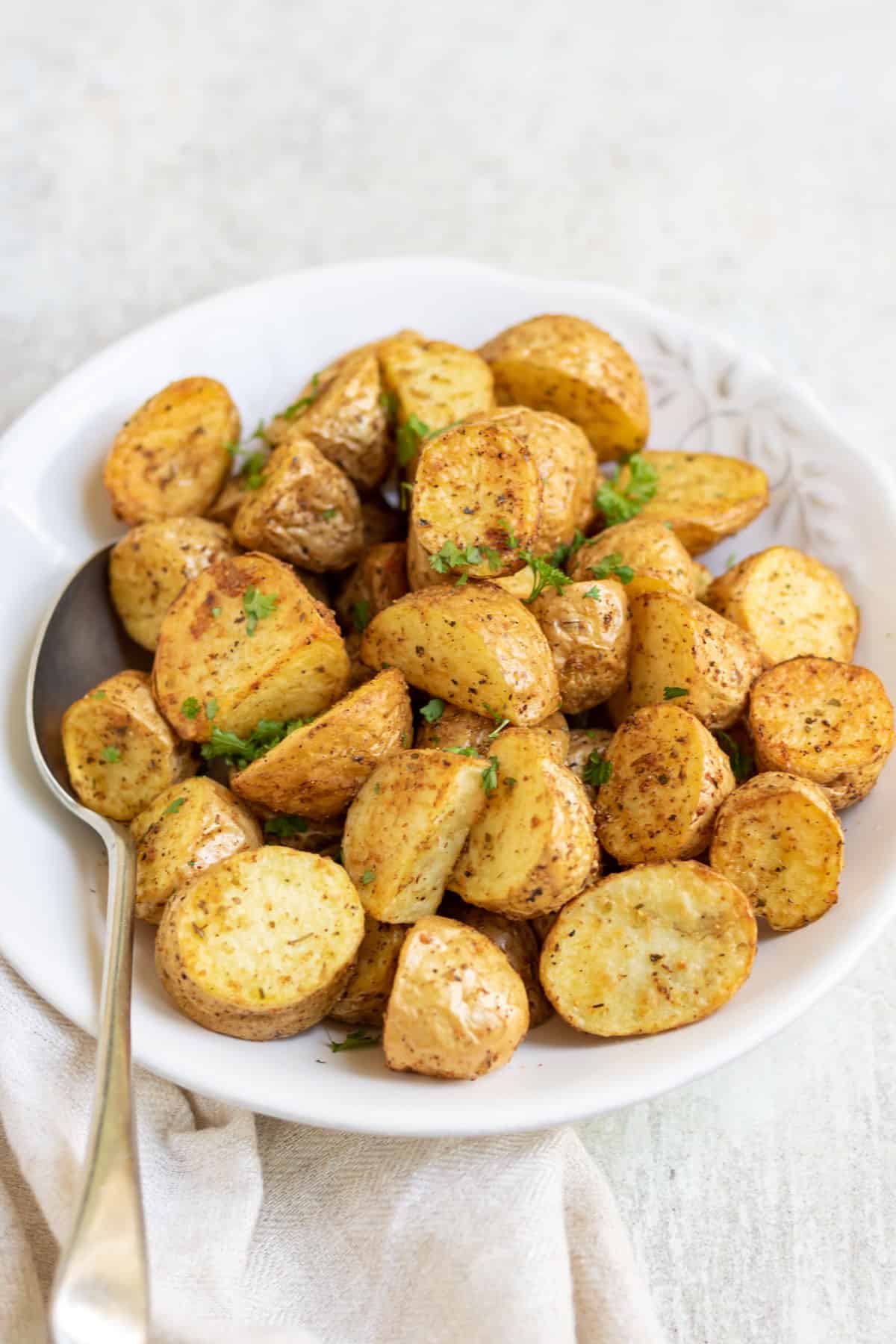 Bowl of air fryer potatoes on a table with a napkin.
