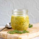 Jar of creamy dill mustard sauce on a table.