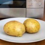 Cooked potatoes in front of a microwave.