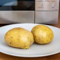 Cooked potatoes in front of a microwave.