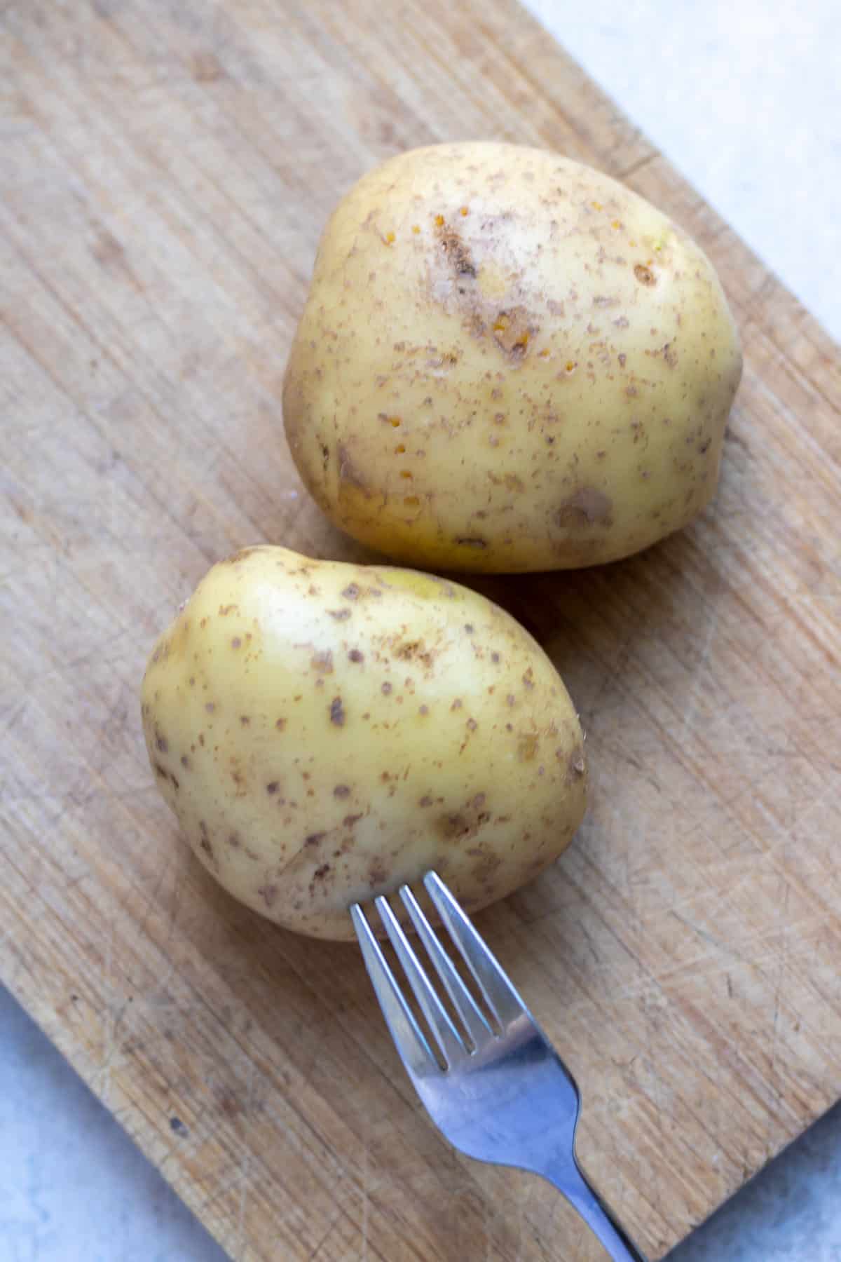 Pricking potatoes with a fork.