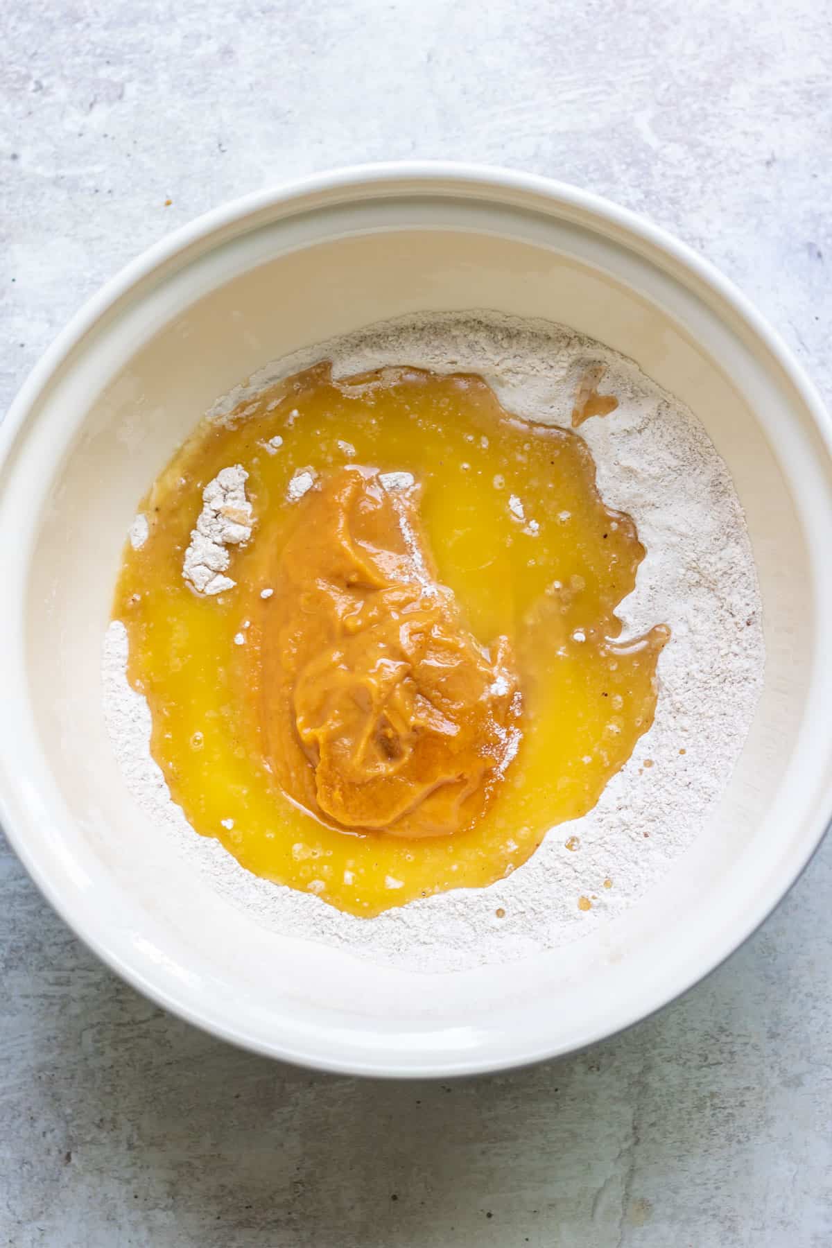 Pumpkin and wet ingredients added to the bowl.