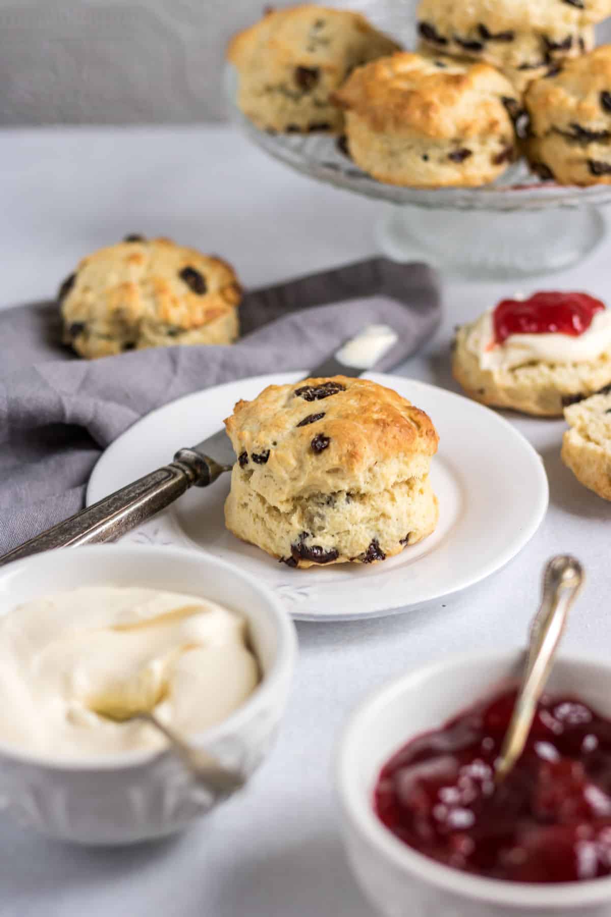 A table with scones, cream and jam.