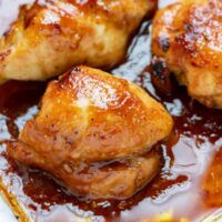 Close up of a baked skinless boneless chicken thigh in a honey garlic marinade.