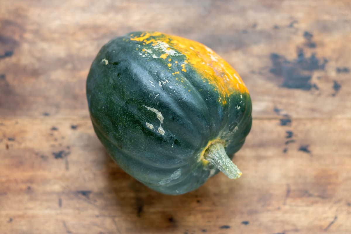 An acorn squash on a wooden table.