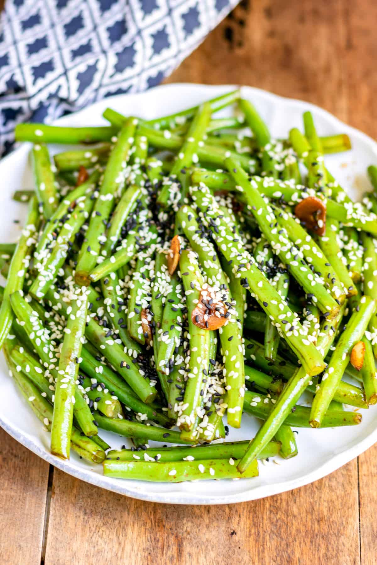 Table with a serving dish of sesame green beans.