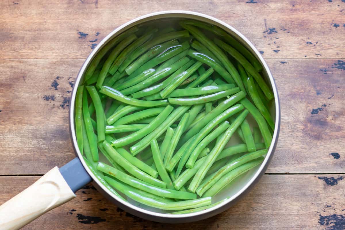 Blanching green beans in boiling water.