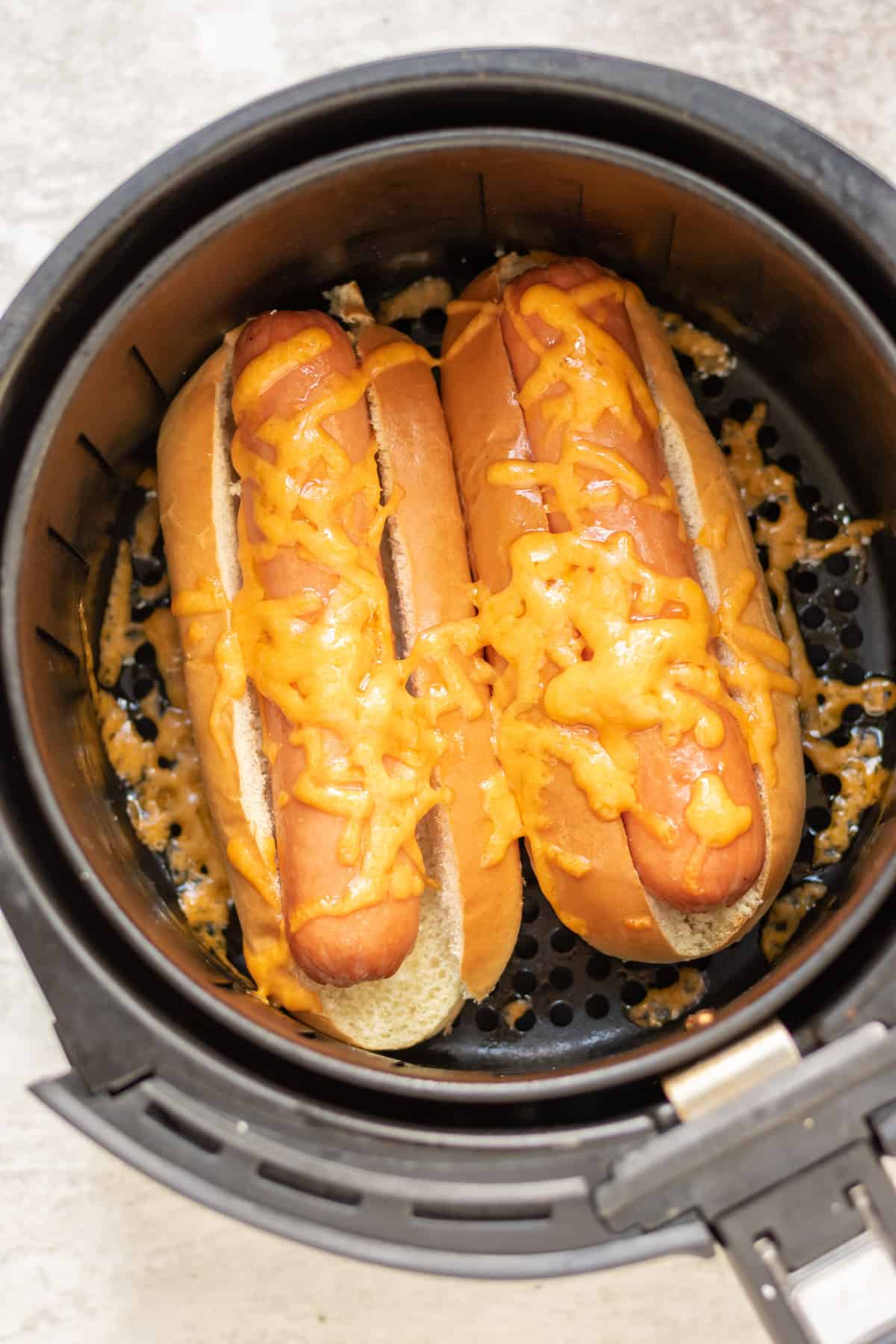 Hot dogs in buns with melted cheese in the air fryer.