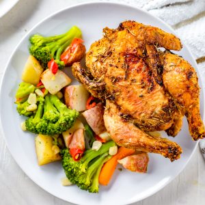A plate with vegetables and an air fried cornish hen.