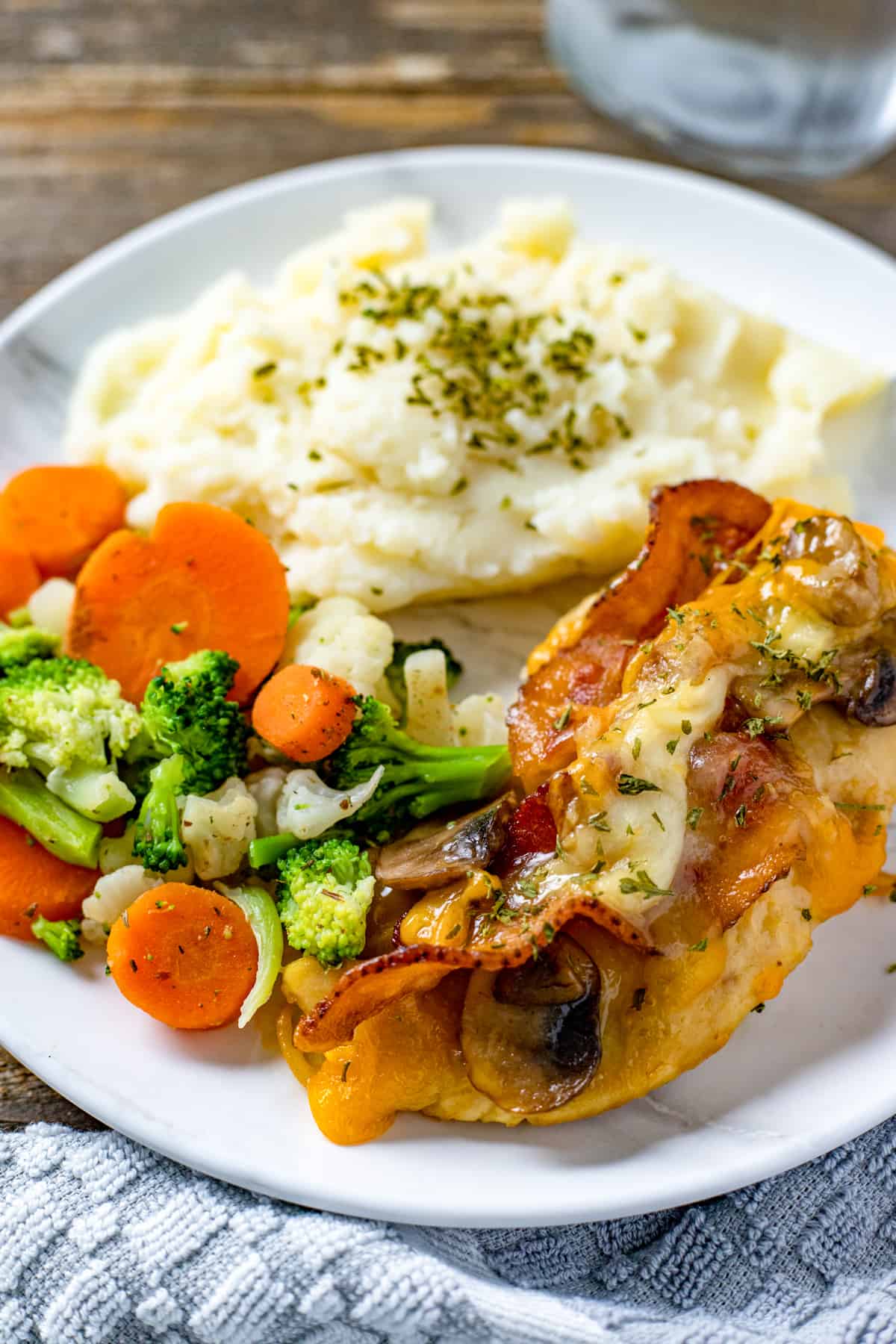 A plate of chicken, vegetables and potato.