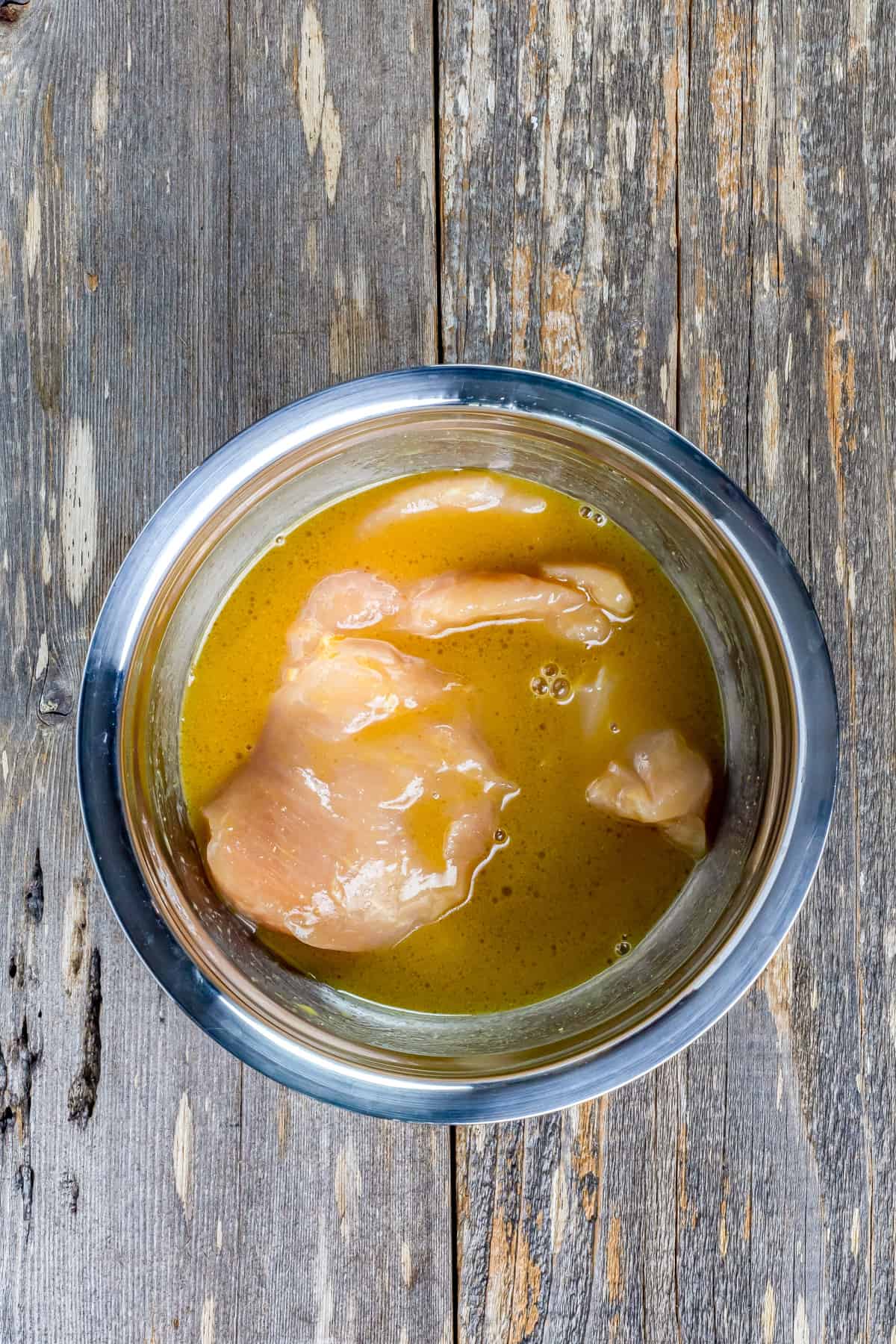 Chicken marinating in honey mustard sauce.