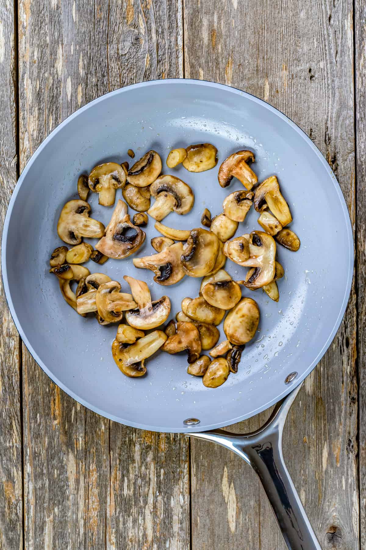 Mushrooms cooking in a skillet.