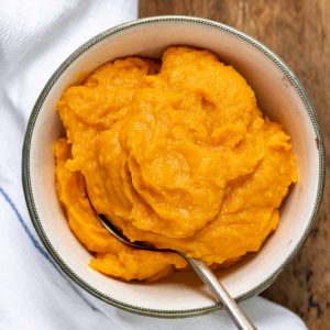 Spoon in a bowl of sweet potato puree.