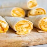 Close up of cheese oozing out of a melted Taco Bell Cheese Roll Up.