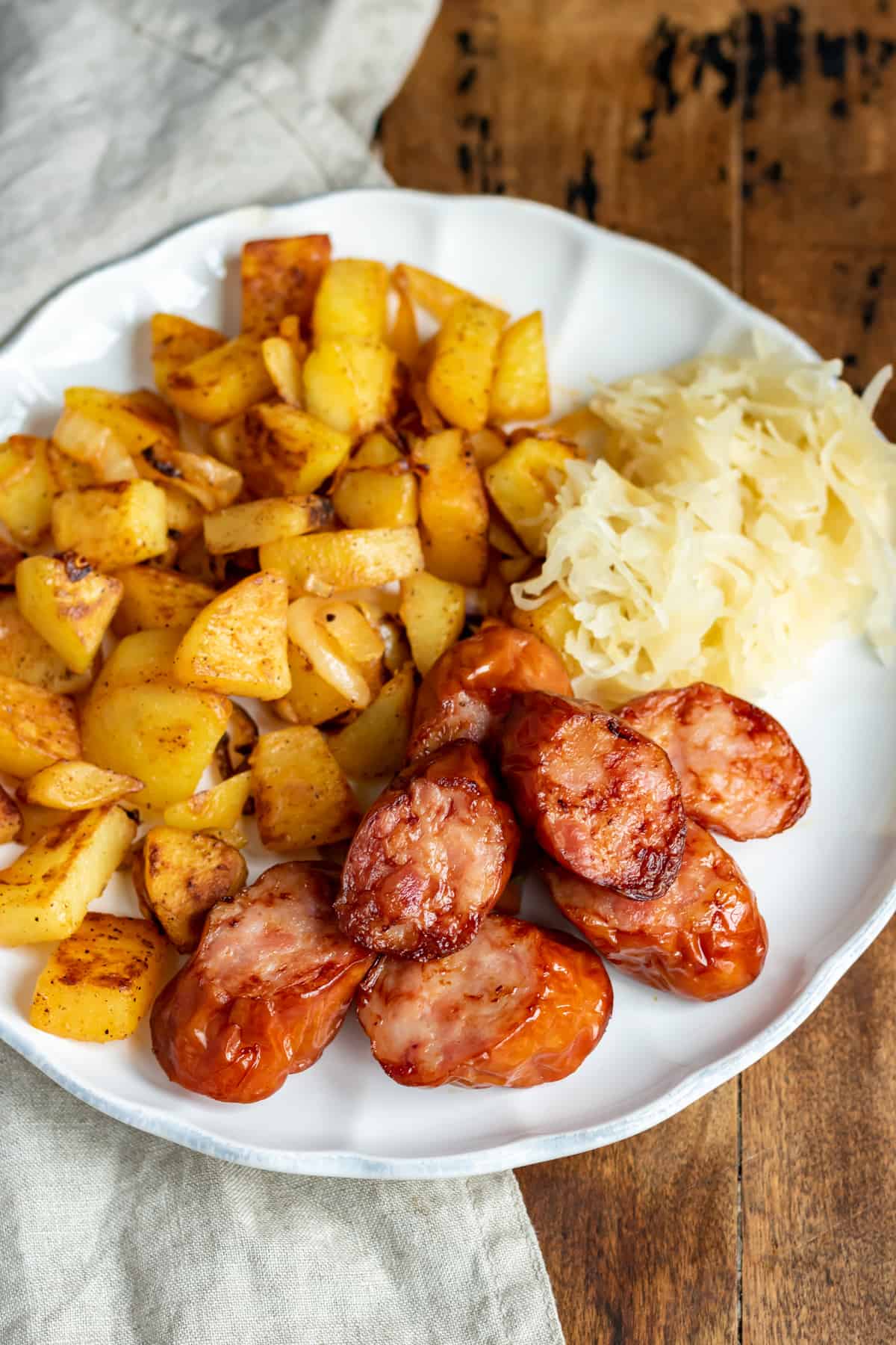 A plate of onions and potatoes, sauerkraut and air fried kielbasa.