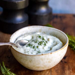 Close up of a bowl of dill aioli on a table.
