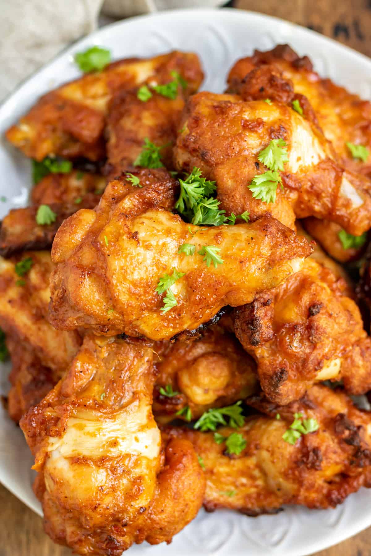 A pile of baked cajun wings on a plate.