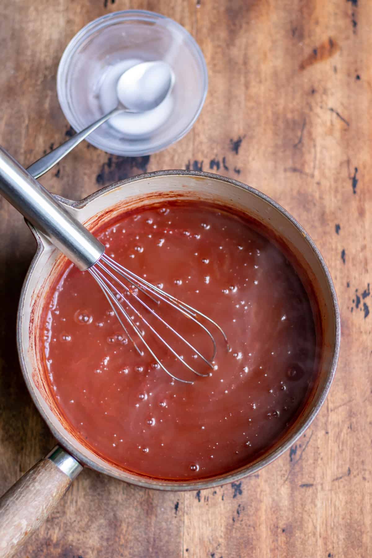 Whisking the cornstarch into the sauce.