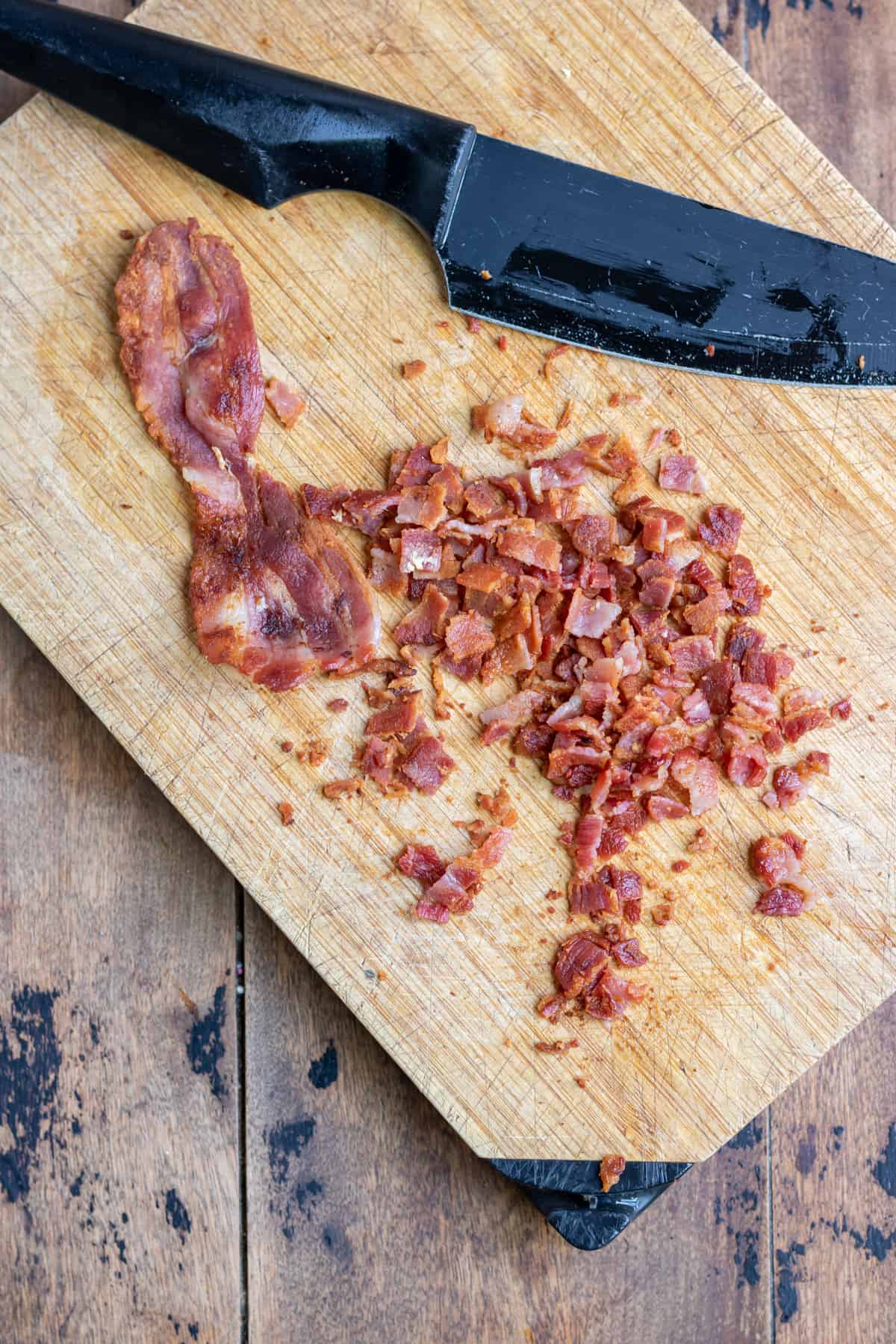 Bacon being chopped on a cutting board.