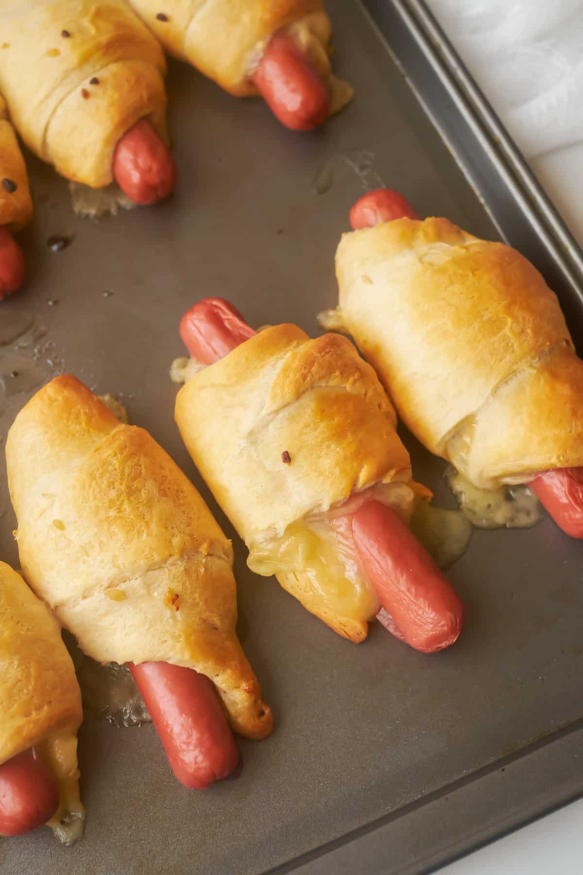 Rows of hot dogs wrapped in crescent rolls.