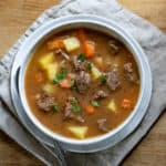 Table with a bowl of slow cooker beef stew.