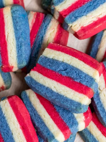 A pile of striped cookies colored red, white and blue.