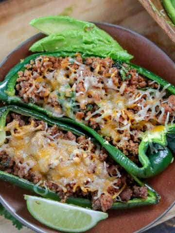 Plate of stuffed poblano peppers on a table.