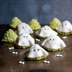 A table with rice krispie treats decorated like ghosts for halloween.