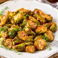 Close up of parmesan brussels sprouts on a serving dish.