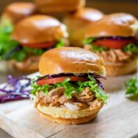 A table with bbq pulled chicken sandwiches.