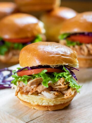 A table with bbq pulled chicken sandwiches.