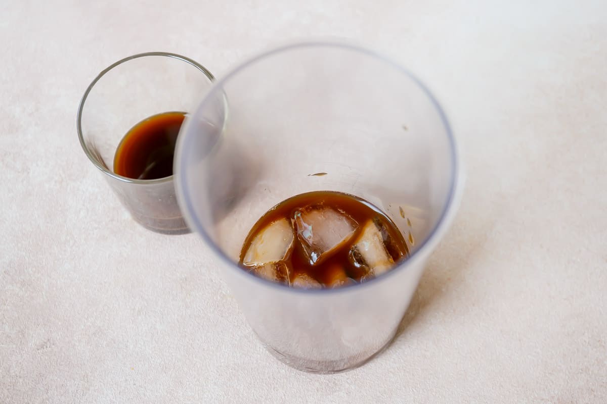 Ice and coffee in a blender jug.