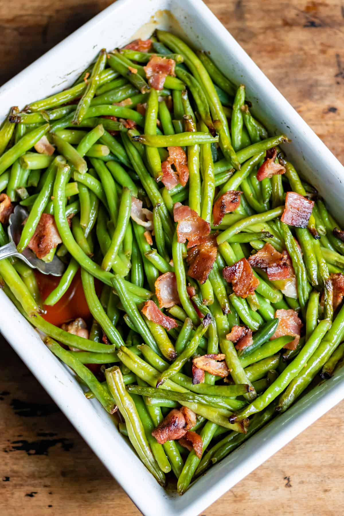 Serving dish of green beans with bacon.