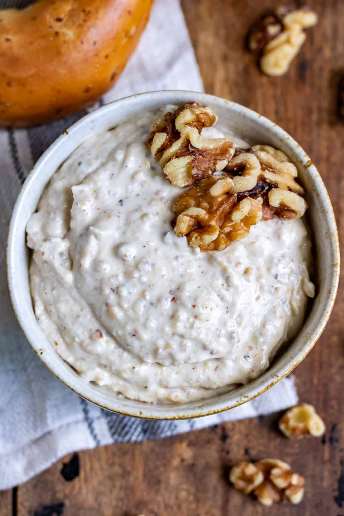 Close up of a bowl of honey walnut cream cheese with a few walnuts on top.