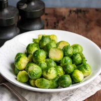Serving dish of microwaved brussels sprouts on a table.