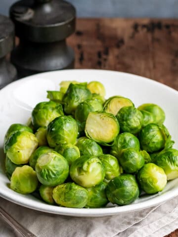 Serving dish of microwaved brussels sprouts on a table.