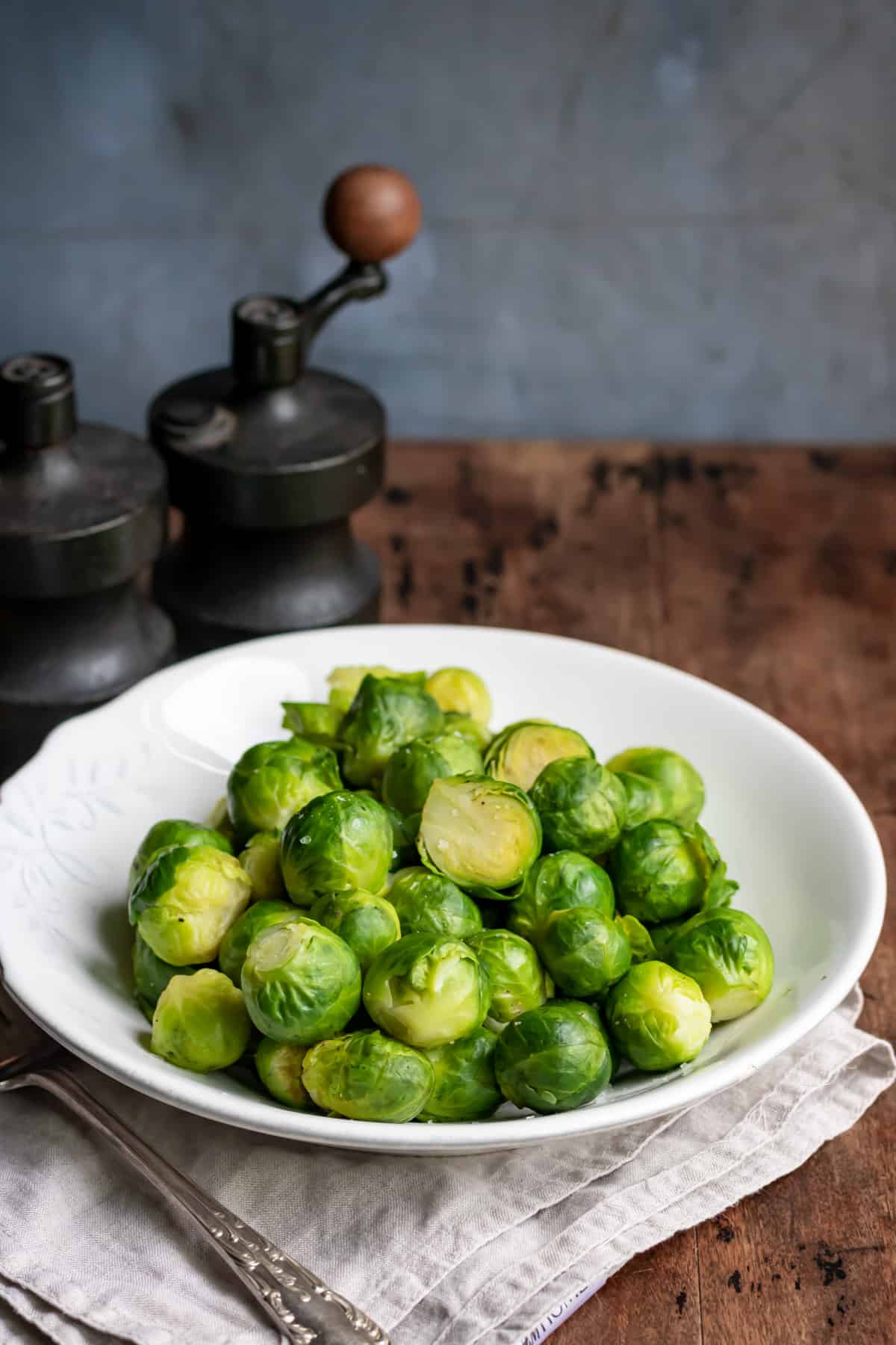 Serving dish of microwaved brussels sprouts on a table.