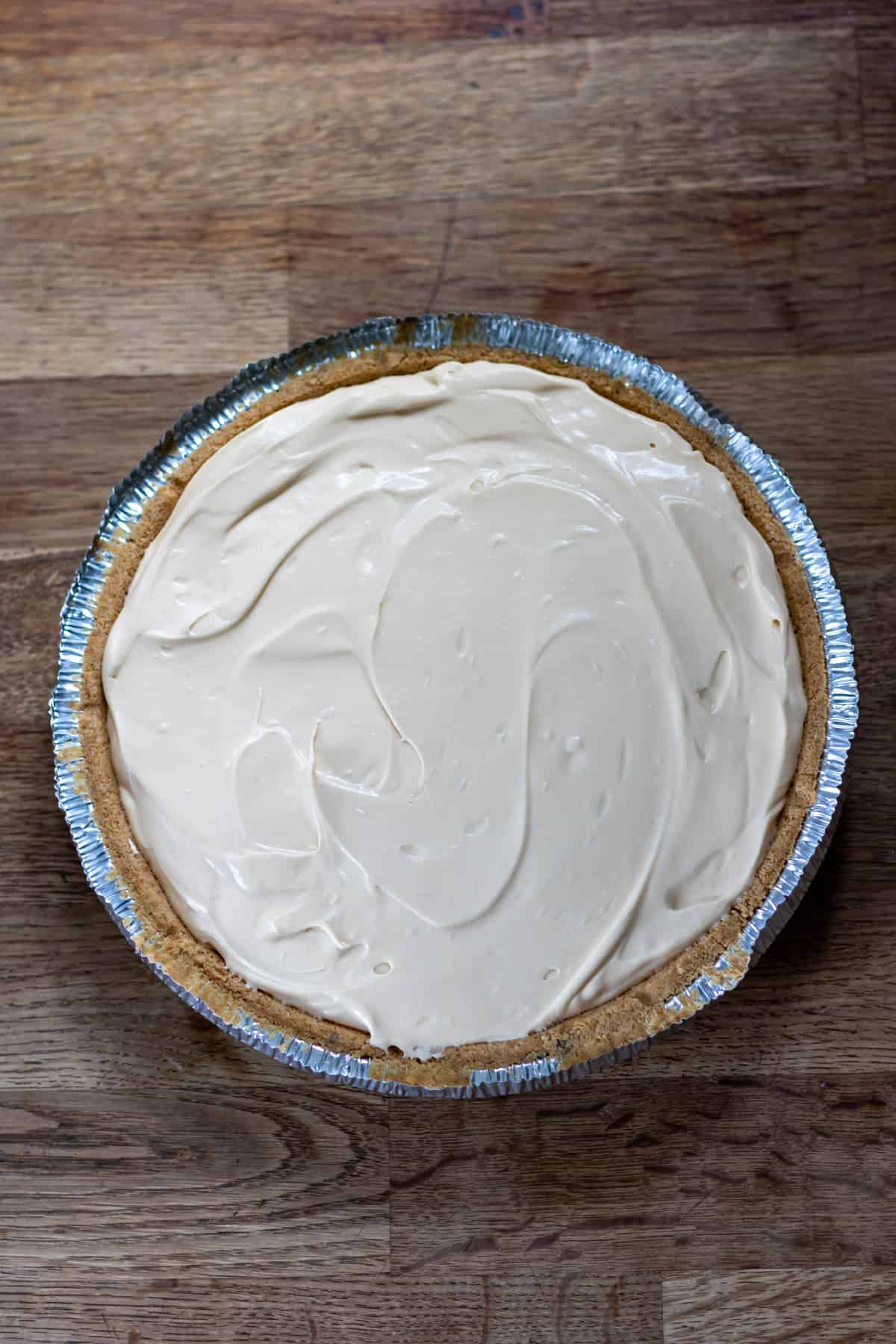 Cheesecake filling poured into pie crust.
