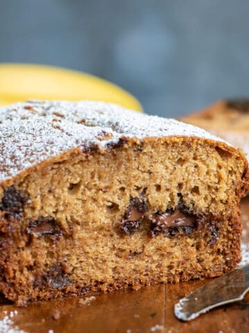 Close up of a chocolate chip banana bread with a slice out.