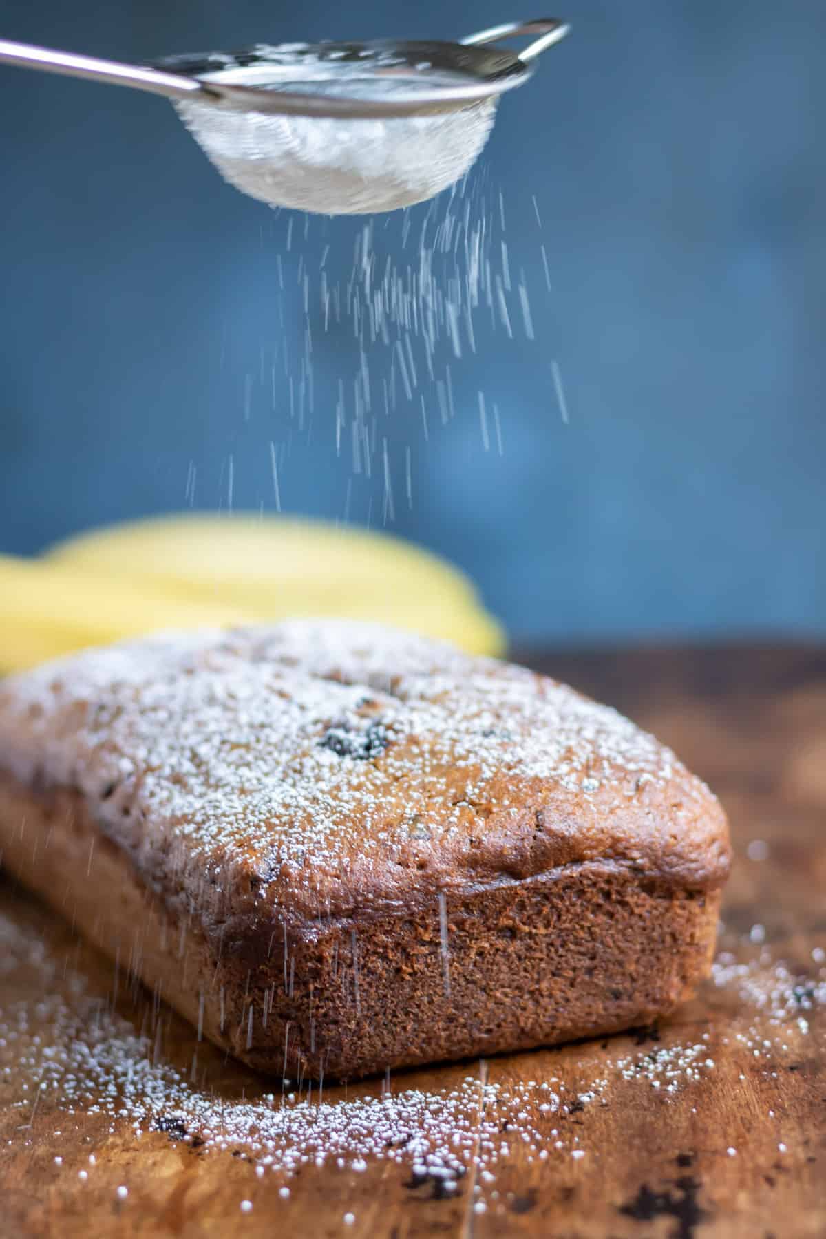 Sprinkling icing sugar onto the banana bread.