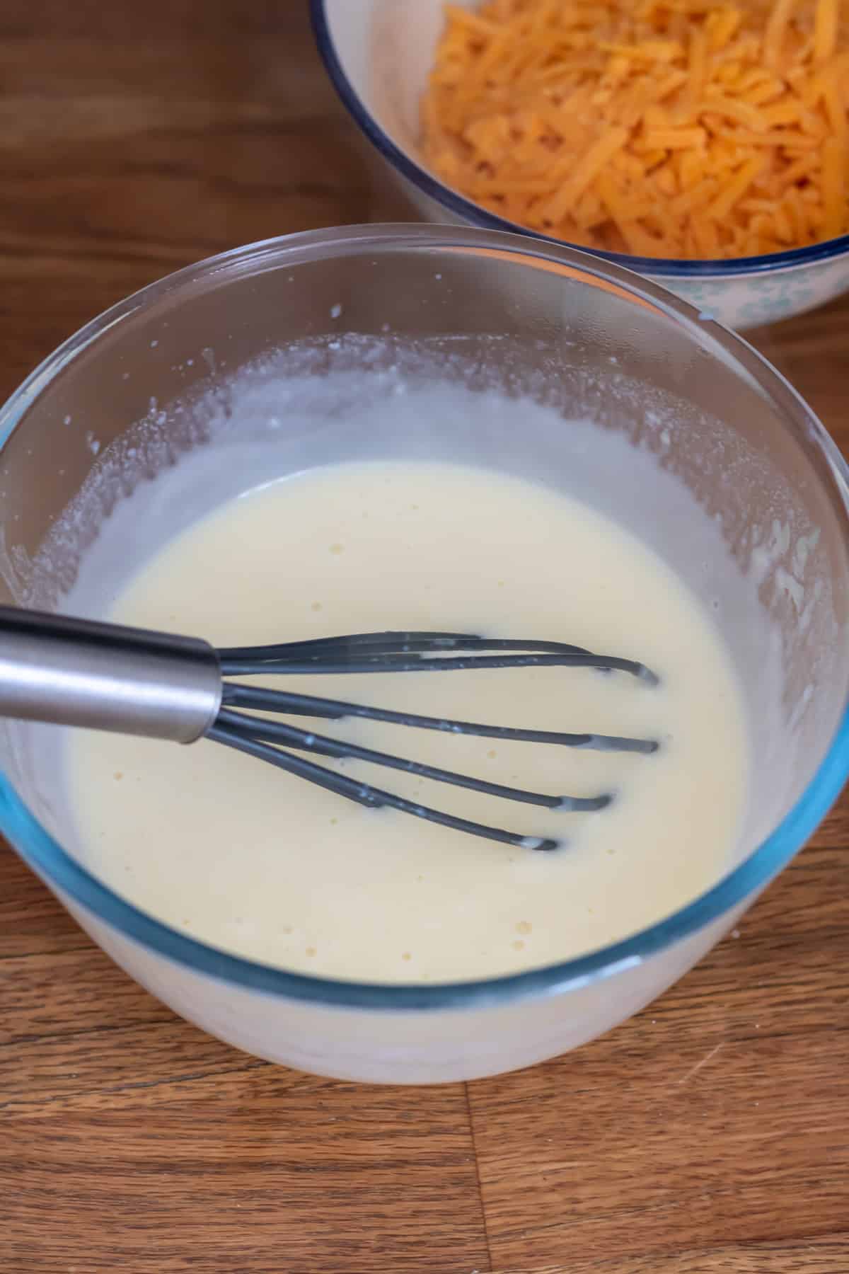 Whisking milk into the flour and butter.