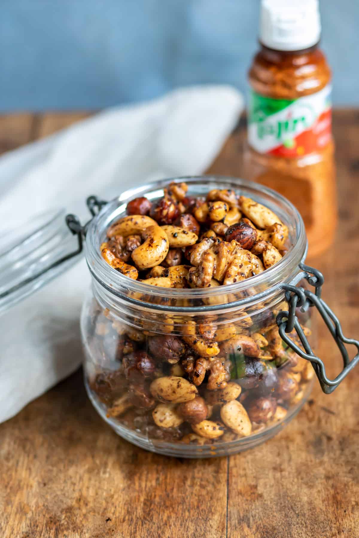 Jar of roasted tajin nuts on a table.