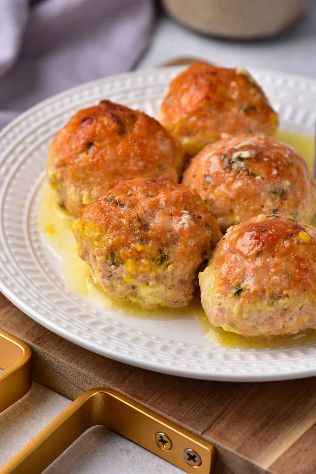 Plate of baked chicken meatballs with garlic butter.