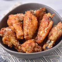 Table with a bowl of garlic parmesan wings.
