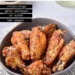 Table with a bowl of wings, text: Garlic and Parmesan Chicken Wings and list of ingredients.
