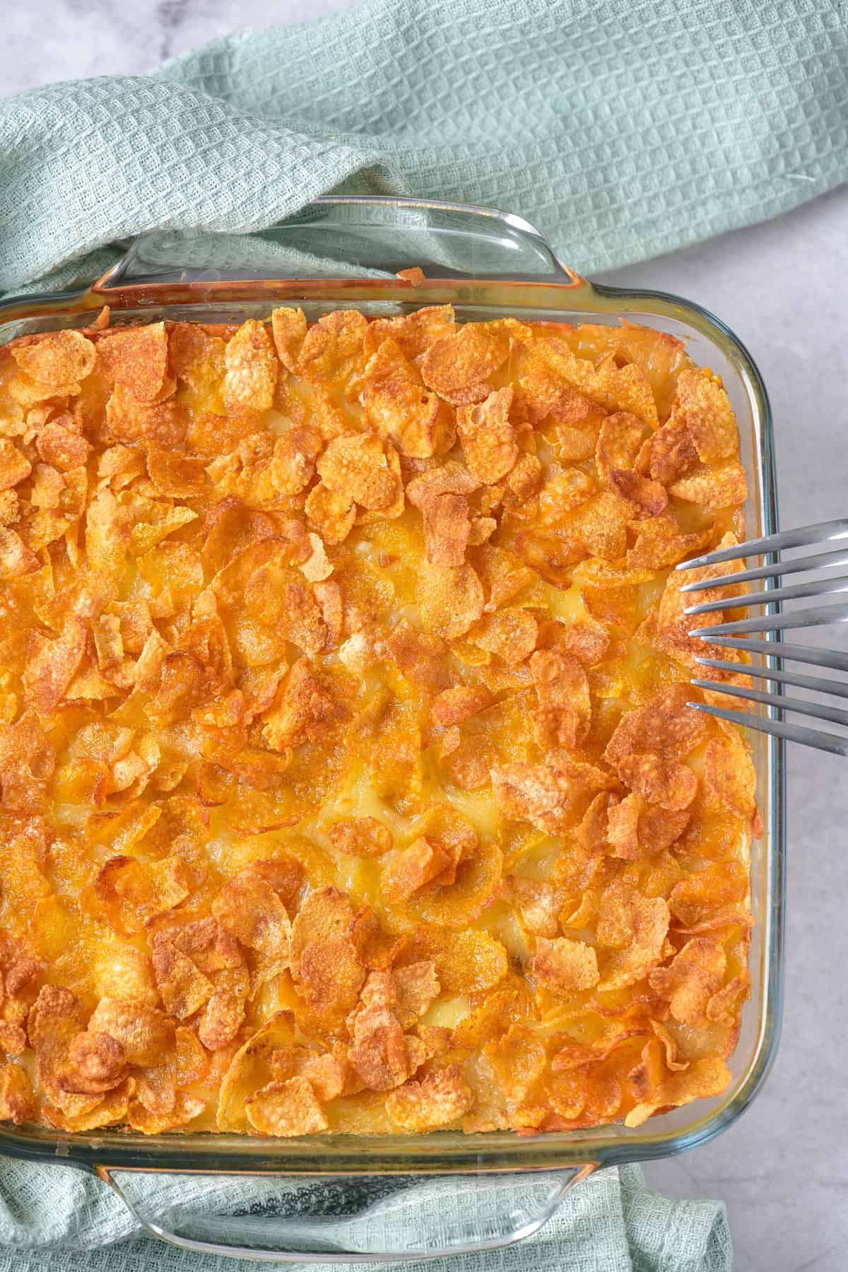 Cooked hashbrown breakfast casserole on a table with a napkin and forks.