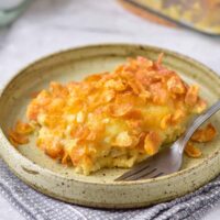 Slice of hashbrown breakfast casserole on a plate with a fork.