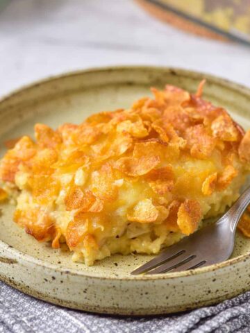 Slice of hashbrown breakfast casserole on a plate with a fork.