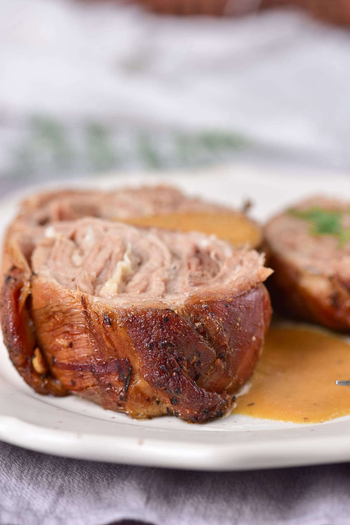 Side view of a sliced portion of roasted rolled lamb.
