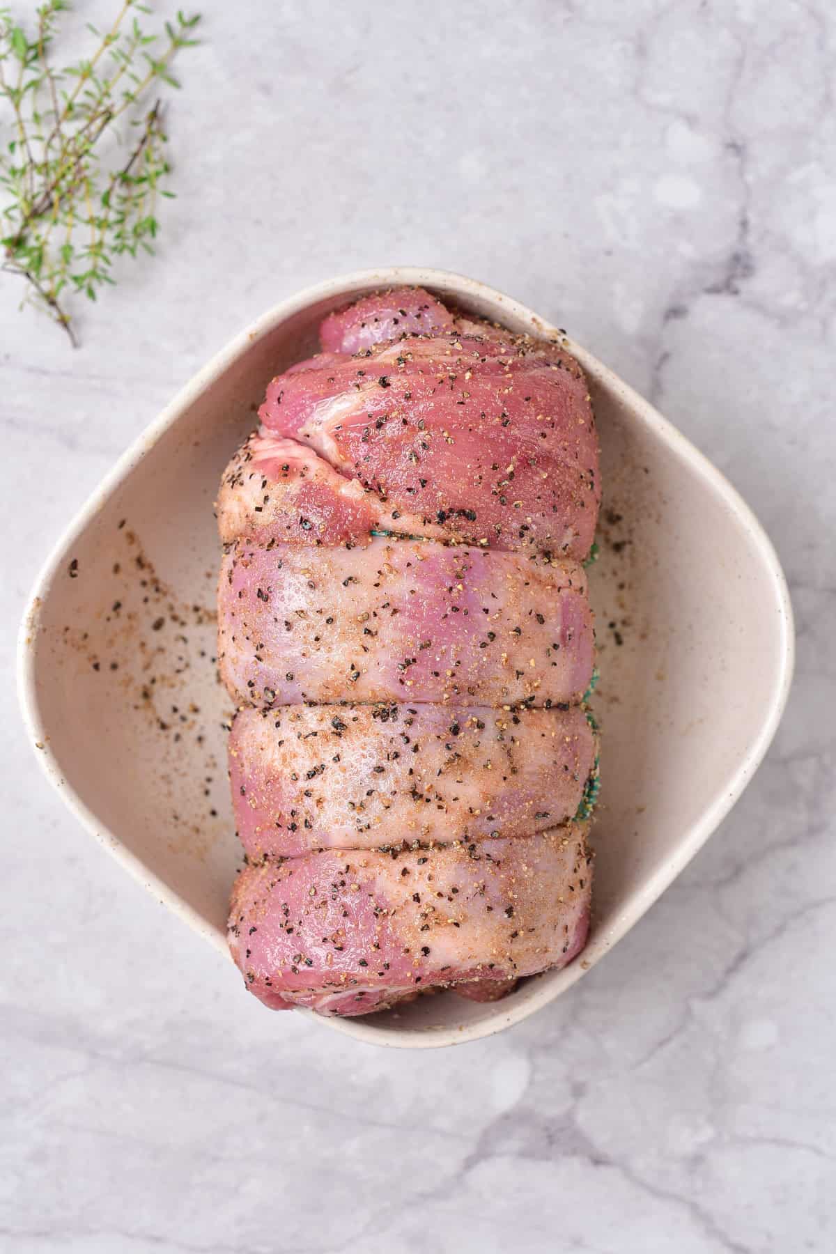 Seasoning the rolled lamb.
